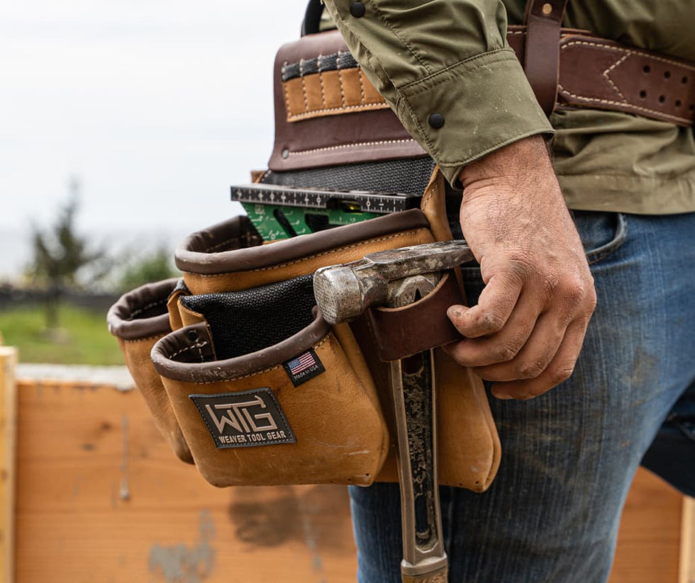 man resting hand on hammer in Weaver Tool Gear tool belt